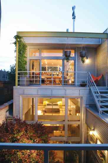 The interior’s stacked layout allows spaciousness within a small footprint. The outdoor walkway just visible on the right is made with recycled plastic and connects Jim’s studio with the guest bedroom, greenhouse and roof gardens.